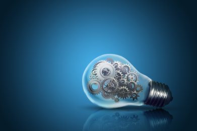 Close,Up,Of,Light,Bulb,With,Gear,Mechanism,Inside,Isolated