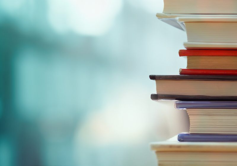 Book,Stack,In,The,Library,Room,And,Blurred,Bookshelf,For